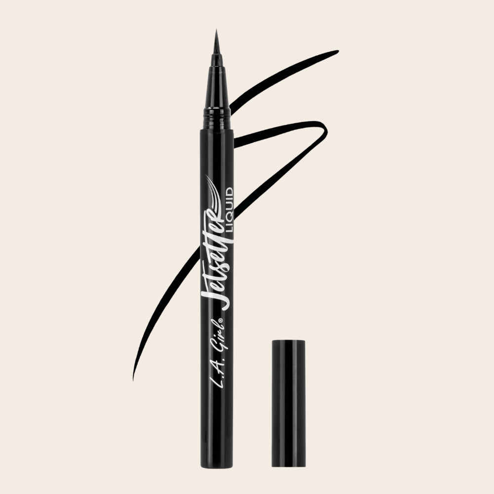L.A. Girl Jetsetter Liquid Eyeliner shown uncapped with a fine brush tip and black eyeliner strokes behind the pen.